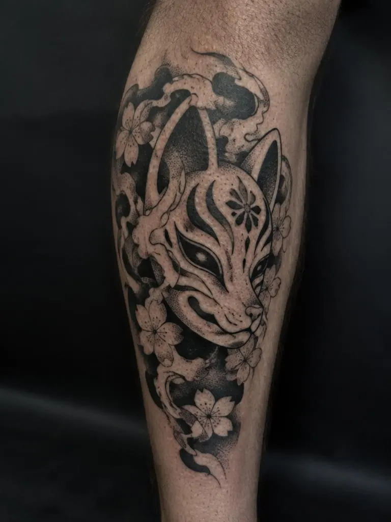 Tatuagem blackwork de máscara de raposa na panturrilha