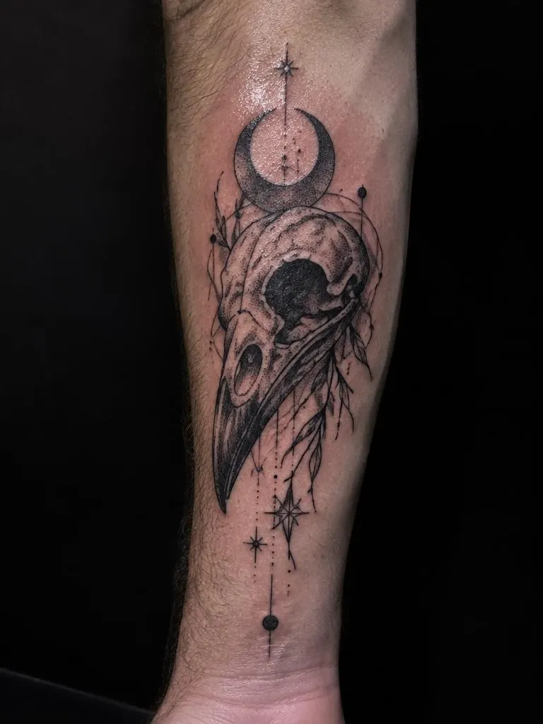 Tatuagem autoral de crânio de corvo com lua